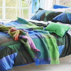 Designersguild Decke - Varanasi Fuchsia Mohair dekoriert auf einem Bett. 
