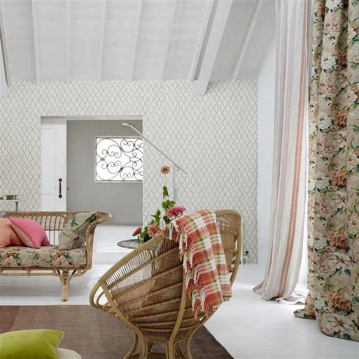 Designersguild Decke - Woodhall Zinnia dekoriert auf einem Rattanstuhl.