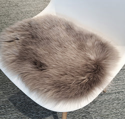 Lammfell-Sitzkissen für Eames Side Chair von Vitra in braun auf einem Stuhl.