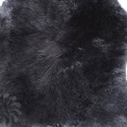 Nahaufnahme Lammfell-Sitzkissen für Eames Armchair von Vitra in schwarz.
